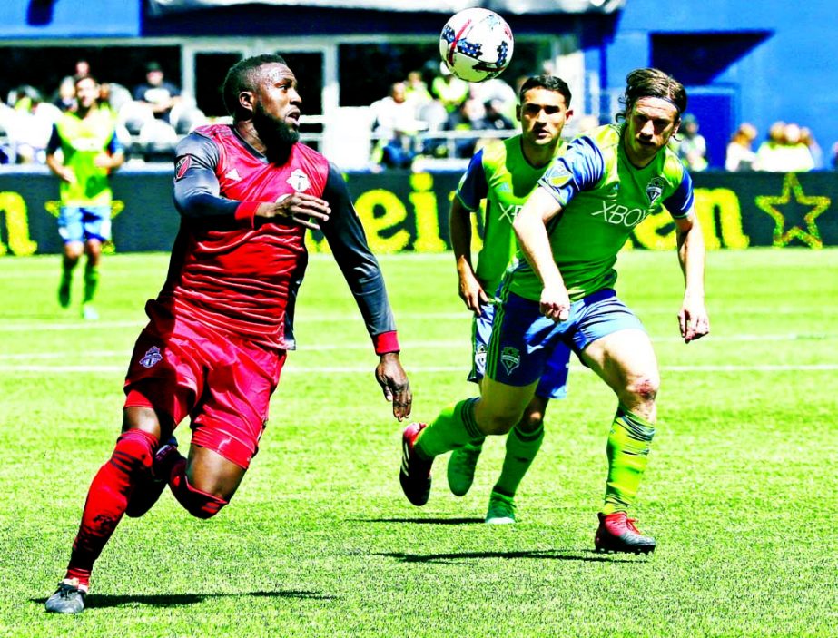 Toronto FC forward Jozy Altidore (left) chases down the ball as Seattle Sounders defender Gustav Svensson (right) and Cristian Roldan (center) look on during the first half of an MLS soccer match in Seattle on Saturday.