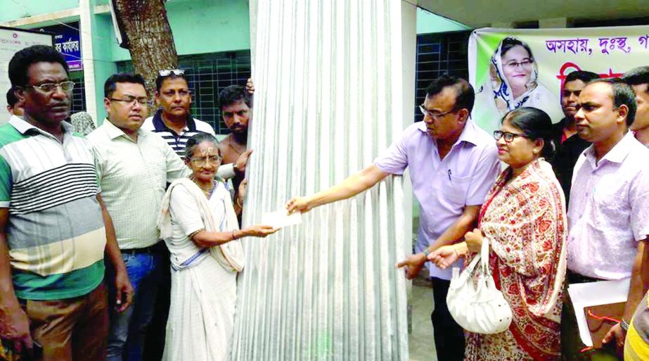 BANARIPARA (Barisal): Golum Faruk, Chairman, Banaripara Upazila distributing corrugated iron sheet among the poor families of the upazila on Tuesday.