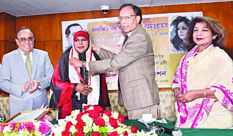 Former Chief Justice K M Hasan handing over the Manik Mia Gold Medal 2017 to legendary singer Shahnaz Rahmatullah at a reception accorded to her by Manik Mia Foundation at Hotel Sonargaon on Friday. Chairman of Manik Mia Foundation Barrister Mainul Hosein