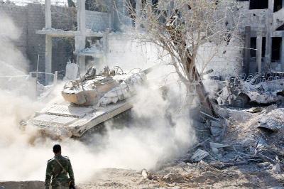 A pro-government tank is driven across rubble in Qabun district, on the outskirts of the Syrian capital Damascus on Saturday.
