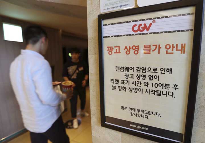 A customer walks by the notice about "ransomware"" at CGV theater in Seoul on Monday."