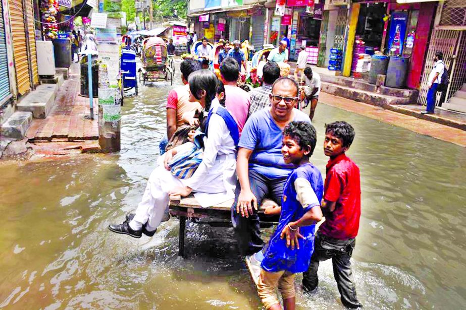 Monday night's rain caused water stagnancy in different parts of the city due to lack of maintenance of the drainage system. People are seen traveling with rickshaw-van while motorized vehicles stopped plying in the stagnant water at Jhikatola on Tuesday