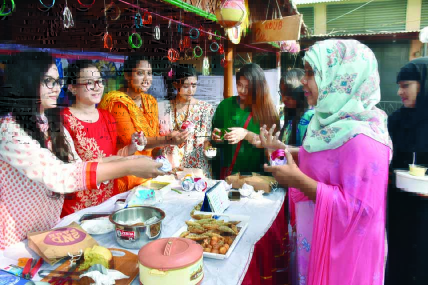 Notre Dame University Bangladesh Cultural Club organised a Pitha Mela (Cake Fair) on the campus on Saturday. The photograph shows the members of the club selling the cakes. Sharmin and Parveen Deepti, LLB (Honours) students, were present, among others.