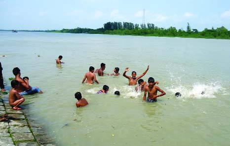 PATUAKHALI: Children trying to cool down themselves amid heat wave. This picture was taken from College Road at Patuakhali town yesterday.