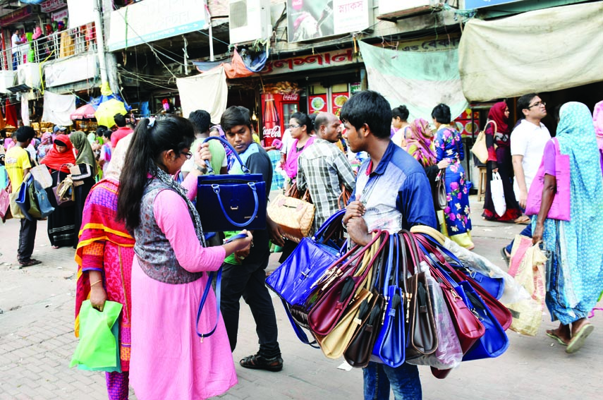 Evicted hawkers seen to selling commodities roaming on the streets without getting any place on the roadside. The snap was taken from the city's Newmarker area on Saturday.