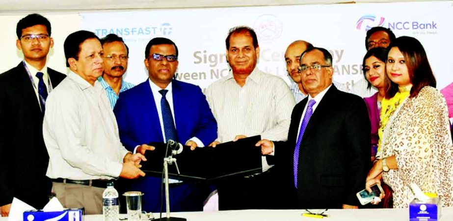 Parikshit Dutta Choudhury, Chairman of Board of Directors and Md Abdur Rouf, Managing Director of Karmasangsthan Bank, AZM Saleh, DMD of NCC Bank and Mohammad Khairuzzaman, Country Director of Operations of TransFast Remittance LLC, exchanging a tri-party