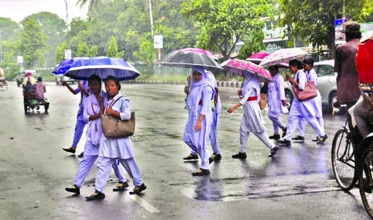 A brief drizzle brings relief to the city dwellers from the scorching heat for a while. The photo shows the students under umbrella during the rain. The snap was taken from the city's Topkhana Road on Sunday.