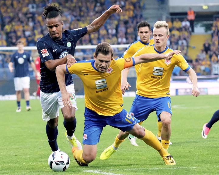 Braunschweig's Ken Reichel (centre) and Nik Omladic vie for the ball with Wolfsburg's Daniel Didavi, during the German Bundesliga soccer match between Eintracht Braunschweig and VfL Wolfsburg at the Eintracht Stadion in Braunschweig, Germany on Monday