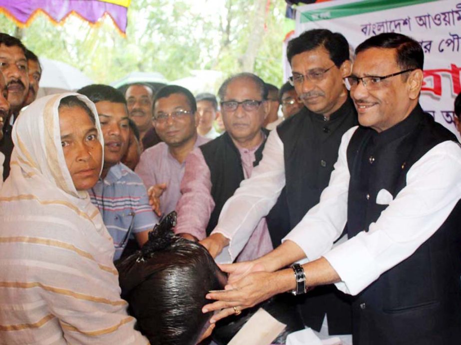 Minister for Road Transport and Bridges and General Secretary of Bangladesh Awami League distributing relief goods among the Cyclone Mora affected people on Friday. NN photo