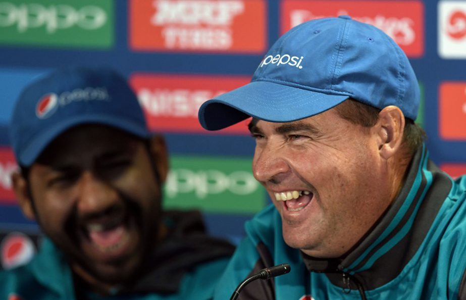 Pakistan coach Mickey Arthur (R) and captain Sarfraz Ahmed share a light moment during a press conference at Edgbaston cricket ground in Birmingham on Saturday ahead of the ICC Champions Trophy cricket match between Pakistan and India.