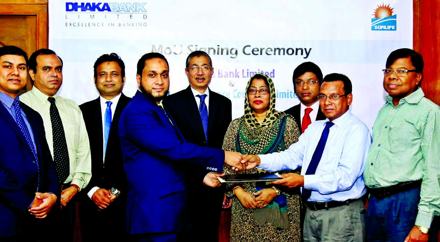Emranul Huq, Acting Managing Director of Dhaka Bank Limited and Prof. Rubina Hamid, Chairperson of Sunlife Insurance Company Ltd. exchanging a MoU singing documents at the banks head office in the city on Tuesday. Mustafa Hossain, Manager of Dhaka Bank Gu