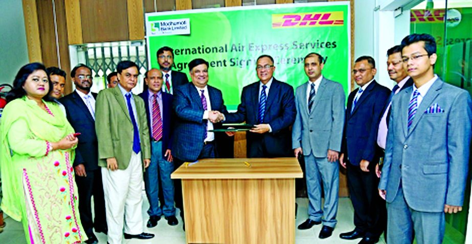 Md Shafiul Azam, Managing Director of Modhumoti Bank Limited and Desmond Quiah, Country Manager of DHL Express Bangladesh exchanging signing agreement documents at the bank head office on Wednesday in the city. SK Talibur Rahman, SEVP, Naim Md Abdur Rashi