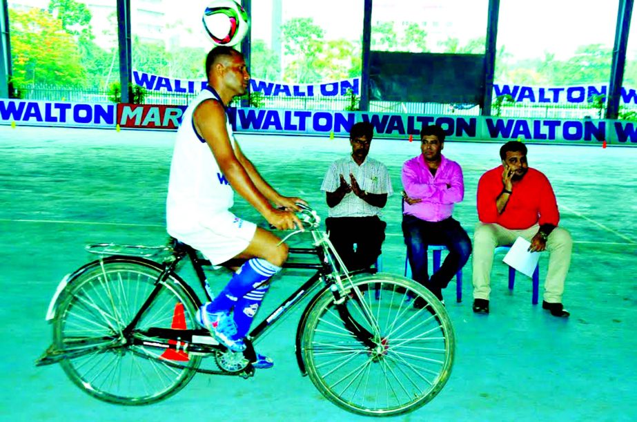 Abdul Halim writing his name on Guinness Book of World Records by riding cycle with a football on his head at the Sheikh Russel Roller Skating Complex on Thursday. Abdul Halim crossed 13.74 km with the ball on his head.
