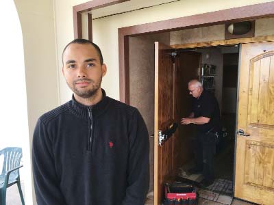 Drew Williams, a member of the Eugene Islamic (Center) poses for a portrait outside the building in Eugene, Ore., as locksmith Jim King upgrades the locks on the front doors.