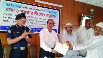 MELANDAH (Jamalpur): Saleh Uddin, Divisional Commissioner, Mymensingh presenting prize to Hafez Solaiman who obtained first position in the division at the Jatiya Shishu- Kishore Quirat Competition on Wednesday.