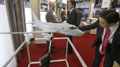 A visitor looks at a miniature model of P-1 Maritime Patrol Aircraft of Kawasaki Heavy Industries, during " MAST Asia", Japan's international arms exhibit, in Chiba, near Tokyo on Monday.