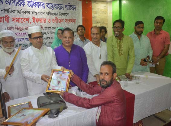 Md Zillur Rahman, DC, Chittagong handing over a crest to President of Maizbhandari Gowsia Hoque Committee Surjogiri Asrom Branch Barun Kumar Acharjo Balai for his outstanding performance to prevent drug and his Maizbhandari research work at an Iftar Mah