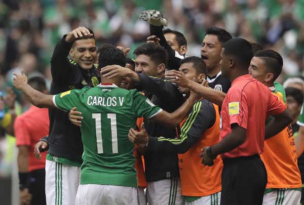 Mexico's Carlos Vela (11) celebrates with bench teammates after scoring his team's first goal against the US during their World Cup soccer qualifying match at Azteca Stadium in Mexico City on Sunday.