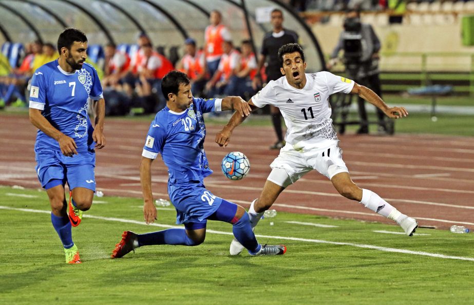 Iran's Vahid Amiri (right) is fouled by Uzbekistan's Davronbek Khashimov (center) as Azizbek Khaydarov follows during their Asia Group A, 2018 World Cup qualifying soccer match at the Azadi Stadium in Tehran, Iran on Monday. Iran became the second team