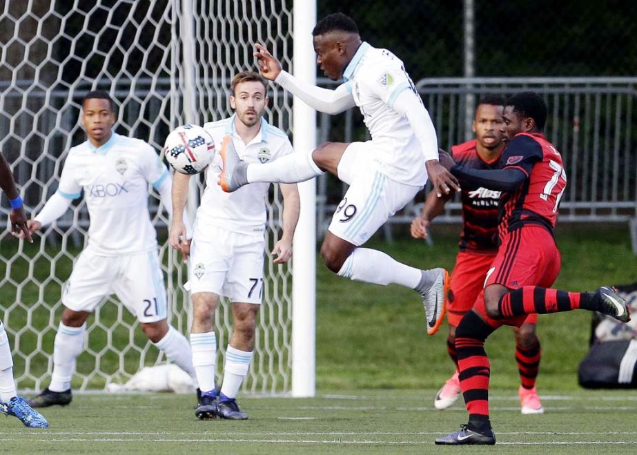 Seattle Sounders forward Felix Chenkam (99) leaps to kick the ball near the goal during the first half of the team's US Open Cup soccer match against the Portland Timbers on Tuesday in Tukwila, Wash.