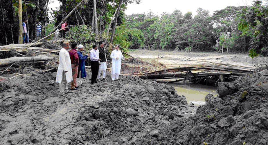 Chairman of the Parliamentary Standing Committee on Ministry of Railway ABM Fazle Karim Chowdhury MP witnessing the demolished one part of the embankment of Sartha Khal during the recent flash flood in Haladia union of Raozan upazila on Saturday.