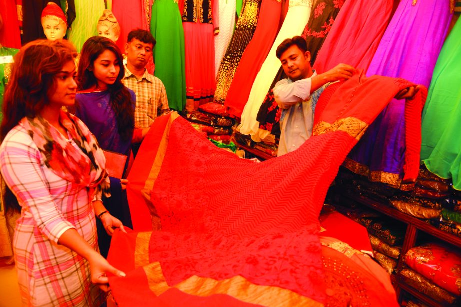 Female buyers making their choices to different frock, lehengas and three pieces ahead of Eid-ul-Fitr. Frock prices range from 25,000 to 30, 000. This picture was taken from Basundhara Shopping Mall on Sunday.