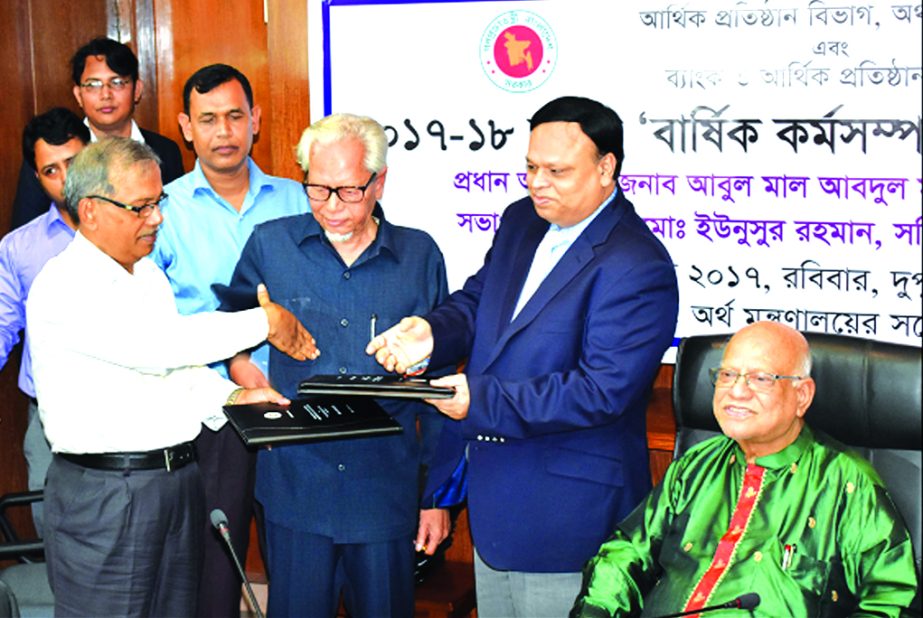 Md. Eunusur Rahman, Secretary of Financial Institutions Division and Shaikh Aminuddin Ahmed, Chairman, Board of Directors of Bangladesh House Building Finance Corporation, exchanging the Annual Performance Agreement (2017-2018) signing documents at the Fi
