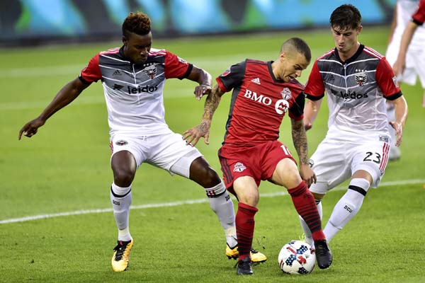 D.C. United midfielders Lloyd Sam (8) and Ian Harkes (23) work to take the ball from Toronto FC forward Sebastian Giovinco (10) during first half MLS soccer action in Toronto on Saturday.