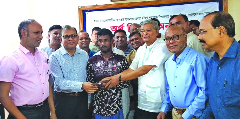 State Minister for Finance MA Mannan and Md Abdus Salam, Managing Director of Janata Bank Limited, handing over cash financial support among the flood afected people of Sunamganj area recently. Md Helel Uddin, DMD of the bank was also present.