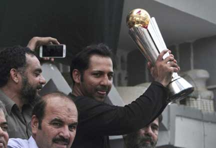 Pakistani cricket team's skipper Sarfraz Ahmed raises Champions Trophy for a crowd gathered to welcome him outside his residence in Karachi, Pakistan on Tuesday. Thousands of fans stayed up late to welcome home members of new Champions Trophy winner Paki