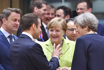 German Chancellor Angela Merkel, center, speaks with British Prime Minister Theresa May, right, and French President Emmanuel Macron, second left, during a round table meeting at an EU summit in Brussels on Thursday.
