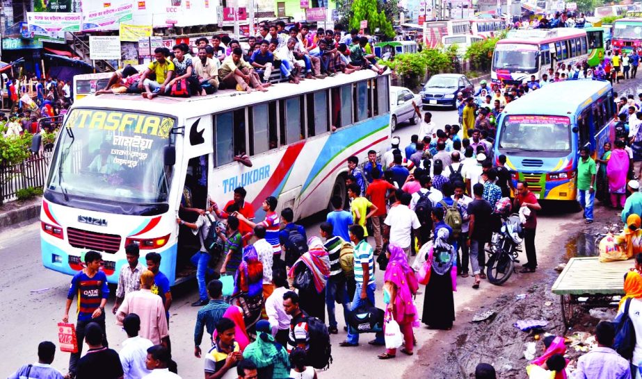 TOTAL CHAOS AT BUS TERMINALS: Hundreds of home-bound people are seen waiting for buses in different areas for several hours due to lack of enough vehicles and many were travelling on rooftop of the buses. This photo was taken from Gabtali-Aminbazar area i