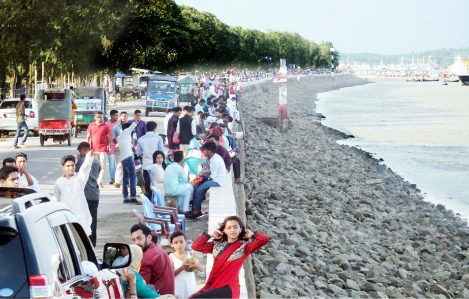 Eid holidaymakers throng Patenga Sea Beach and Naval on Monday.