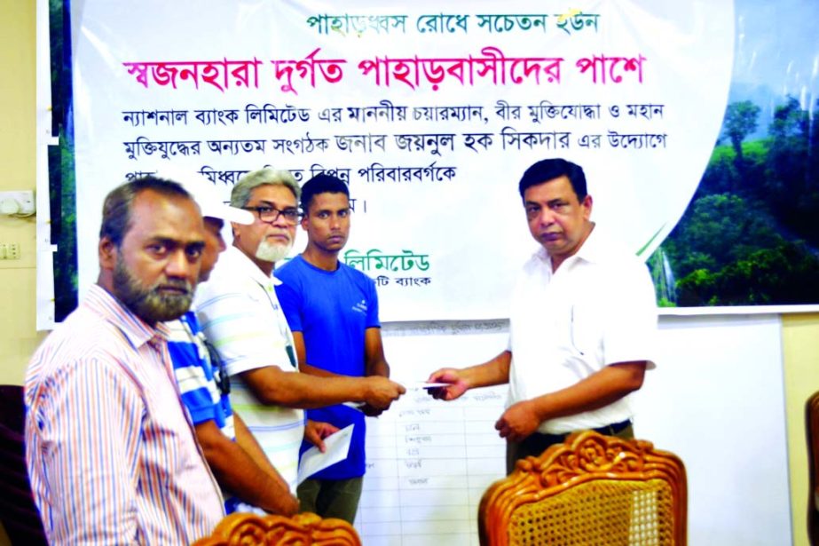 Nizam Ahmed, Regional Head (CC) and SEVP of National Bank Ltd, presenting a donation cheque to the victims of the land slide caused by the recent heavy rain at Rangamati recently. Mohammad Manzarul Mannan, DC and Abu Shahed Chowdhury, ADC of Rangamati we