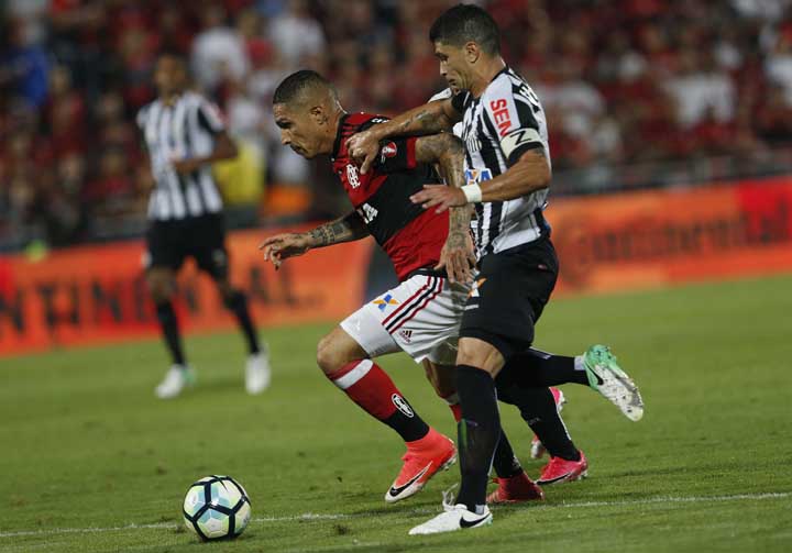 Flamengo's Paolo Guerrero (left) fights for the ball with Santos' Renato during a Copa do Brasil soccer game in Rio de Janeiro, Brazil on Wednesday.