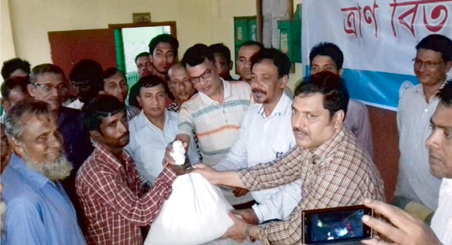 Rangamati Zilla Parishad distributing relief materials among the fire victims of Longudu Upazila recently.
