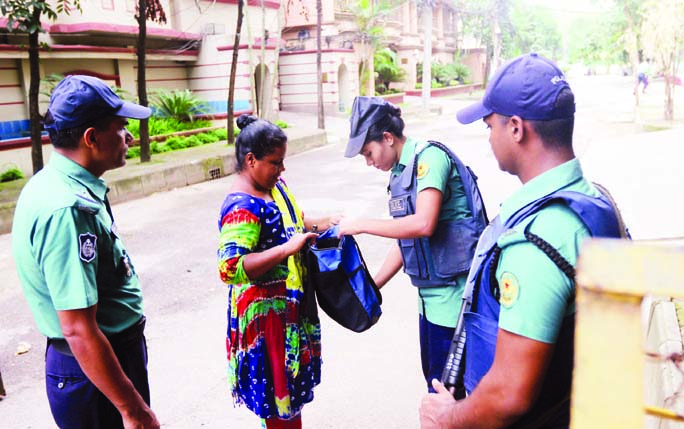 Law enforcers checking bags of the people for security reason. The snap was taken from the city's Gulshan on Saturday marking one year of Holey Artisan Bakery attack.