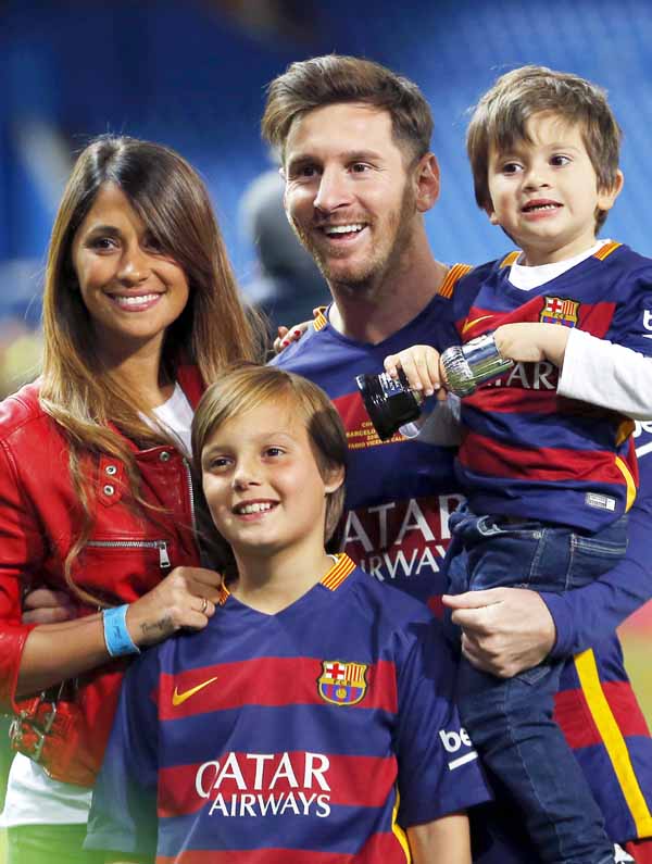 FILE - This is a Sunday, May 22, 2016 file photo of Barcelona's Lionel Messi carrying his son, poses for a photo with his girlfriend Antonella Roccuzzo as they celebrate after winning the final of the Copa del Rey soccer match between FC Barcelona and