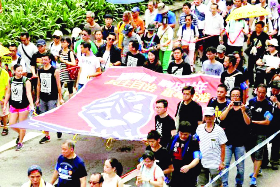 Pro-democracy protesters carry a banner which reads 'One Country, Two Systems, a cheating for twenty years. Recapture Hong Kong with democracy and self-determination', during a demonstration on the 20th anniversary of the territory's handover from Brit