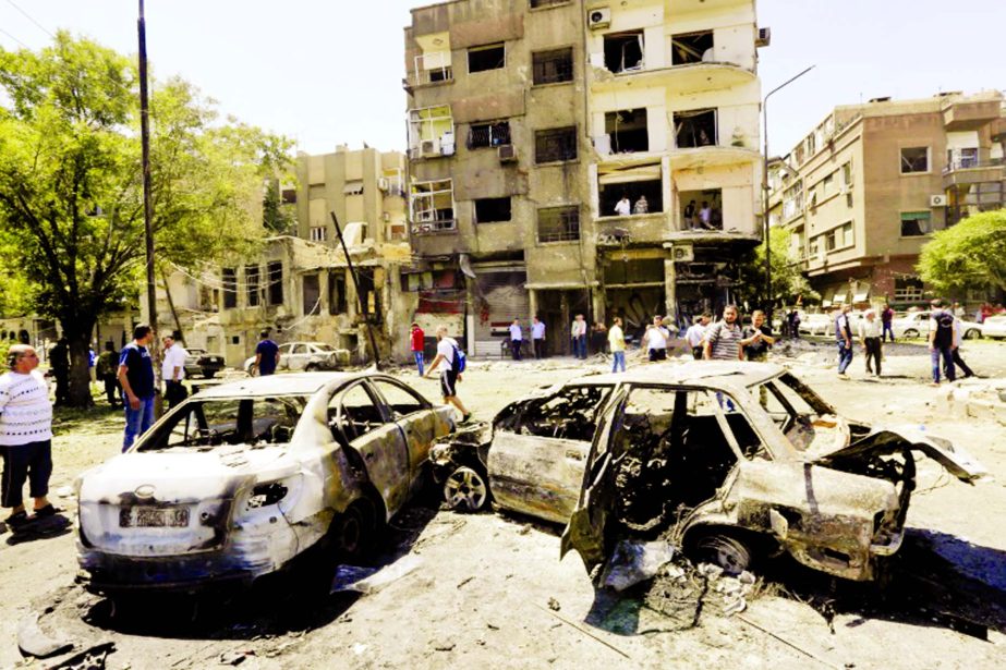 Charred vehicles are seen on the site of a suicide bomb attack in the Syrian capital's eastern Tahrir Square district on Sunday.