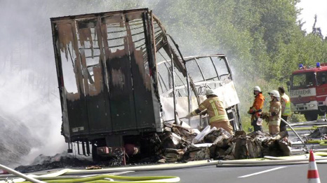 Firefighters are seen at the site where a coach burst into flames after colliding with a lorry on a motorway near Muenchberg, Germany in this still image taken from video on Monday.