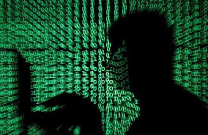 A man holds a laptop computer as cyber code is projected on him in this illustration picture. AP file photo