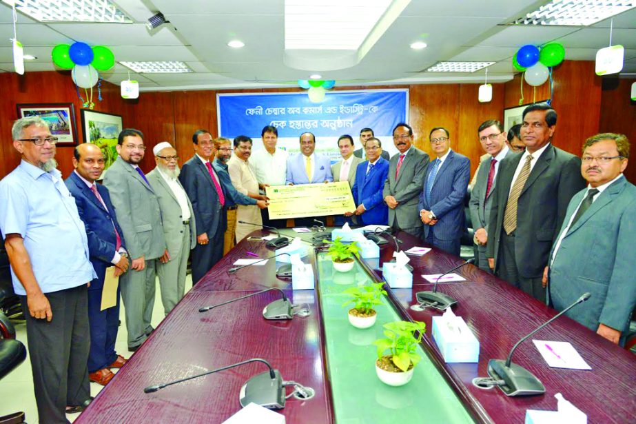 Shahidul Ahsan, Chairman, Mercantile Bank Limited, handing over a cheque to Abdur Rais Kaizar, Senior Vice-President of Feni Chamber of Commerce and Industry at the bank's head office in the city on Monday. Directors Akram Hossain (Humayun), ASM Feroz Al
