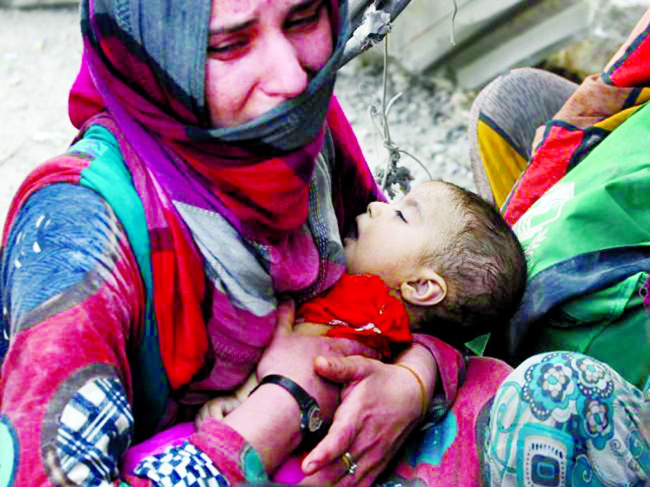 An Iraqi woman carries a child while fleeing from the Old City of Mosul during the Iraqi government's offensive to retake the city from Islamic State fighters.