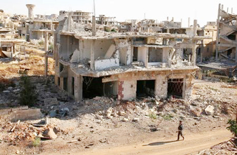 A rebel fighter walks past damaged buildings in a rebel-held part of the southern city of Deraa, Syria.
