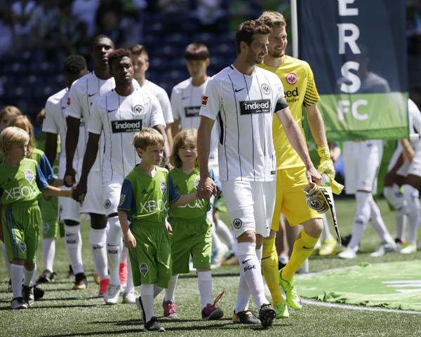 Eintracht Frankfurt players, including goalkeeper Lukas Hradecky (right) and defender David Abraham (second from right) are escorted onto the pitch by young fans before an international friendly soccer match against the Seattle Sounders on Saturday.
