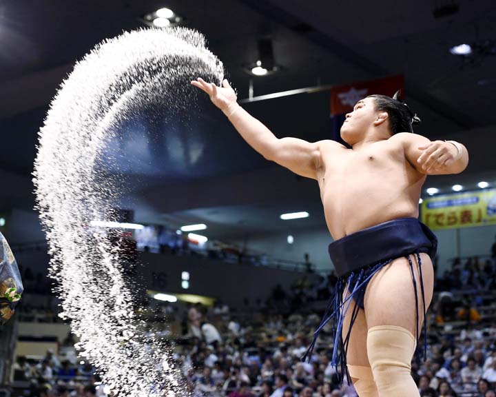 In this Sunday, July 9, 2017 photo, sumo wrestler Terutsuyoshi throws salt in the air during the Nagoya Summer Grand Sumo tournament in Nagoya, central Japan.