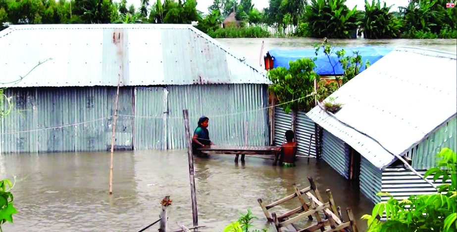 KURIGRAM: Flooded people in Kurigram is carrying their households to safer place. This picture was taken from Khayer Alga area in Sadr Upazila on Tuesday.