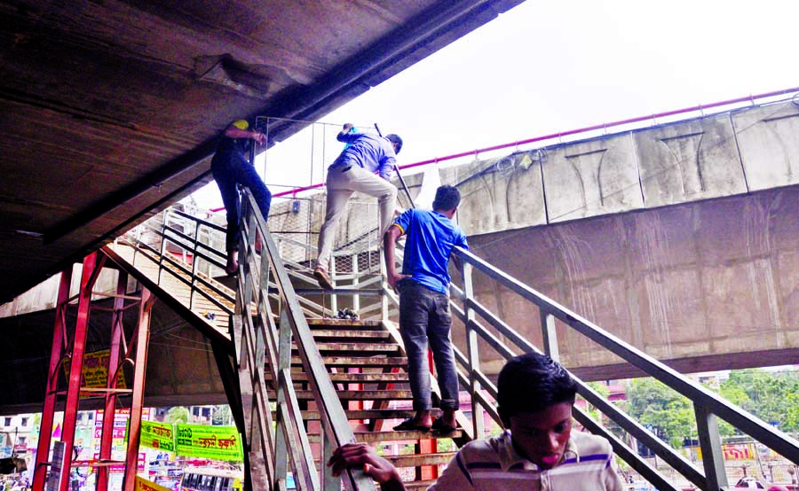 Though Dhaka South City Corporation closed illegal stairs of Mayor Hanif Flyover at Saidabad and Jatrabari points, people climbing the barbel wire fence taking risk of life and violating the court order for short-cut way. This photo was taken from the Jat