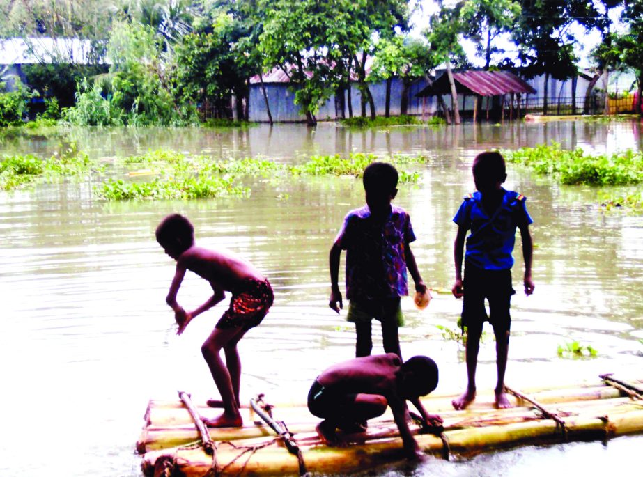 SAGHATA (Gaibandha ): Children at Saghata Upazila playing on the yard in flood water as the whole homestead has been flooded . This picture was taken yesterday.